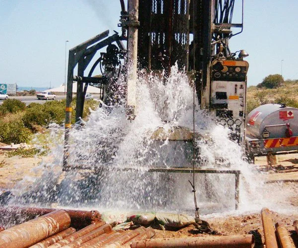 Borehole drilling and casing installation on a property