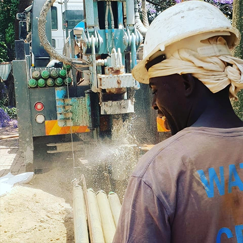 Borehole Specialists worker with water pump equipment at the truck