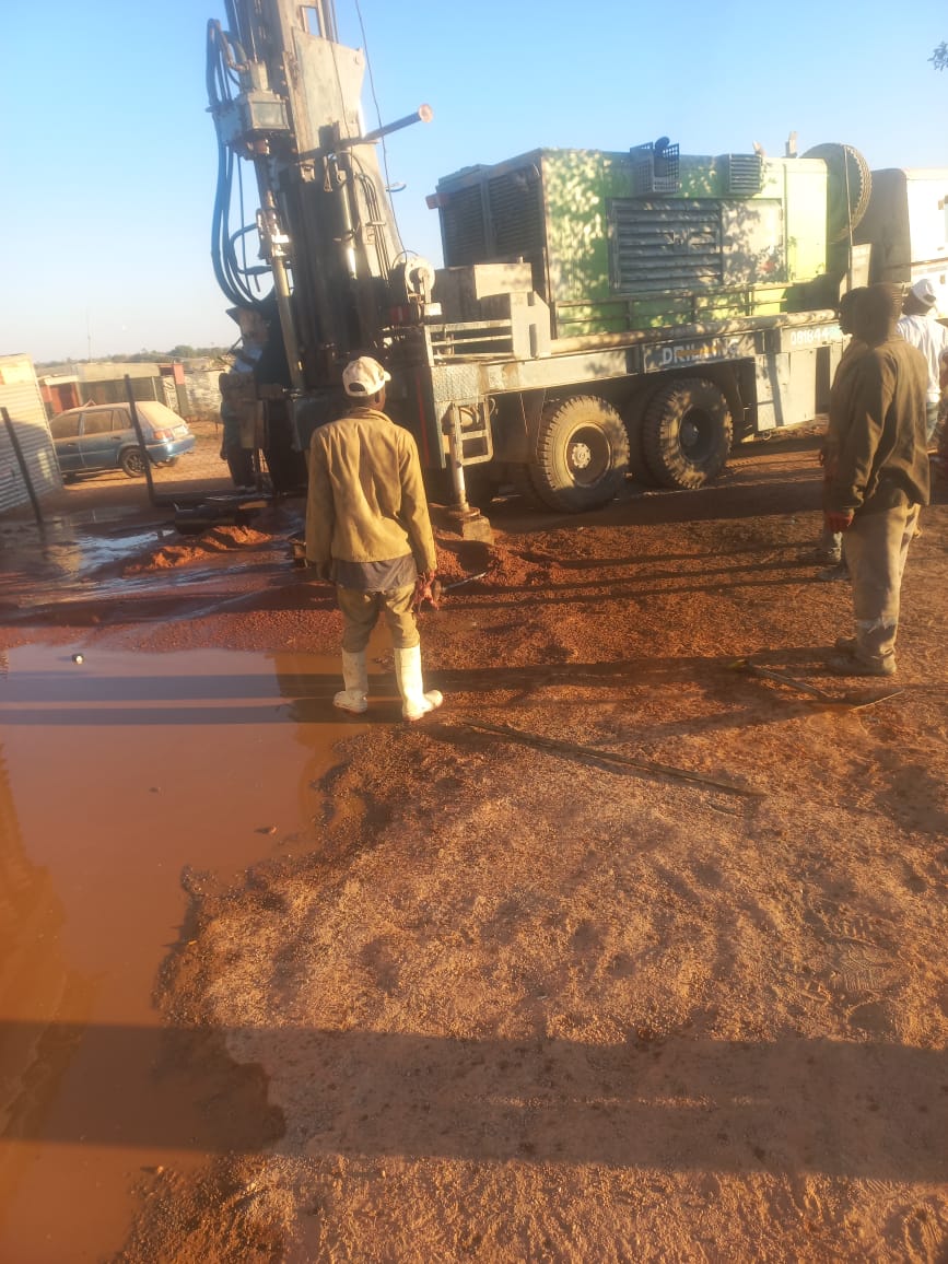 Borehole drilling in progress, rig actively drilling into the ground